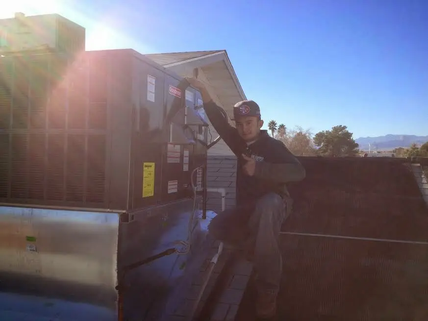 HVAC technician performing Boiler Repair on a rooftop unit in Lancaster